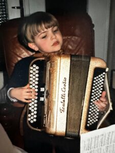 Pierre-Alexis Levrier enfant jouant de l’accordéon, symbole d’une passion musicale née dès l’enfance.